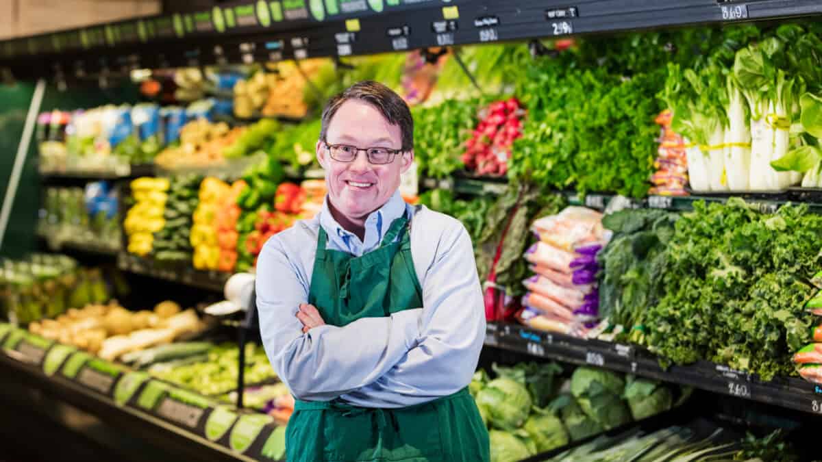 Man with down syndrome working in supermarket.