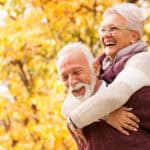 Retired couple hugging and laughing.