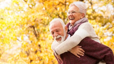 Retired couple hugging and laughing.