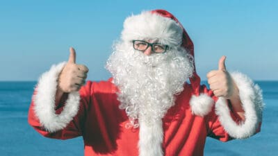 Man dressed as santa giving a thumbs up.