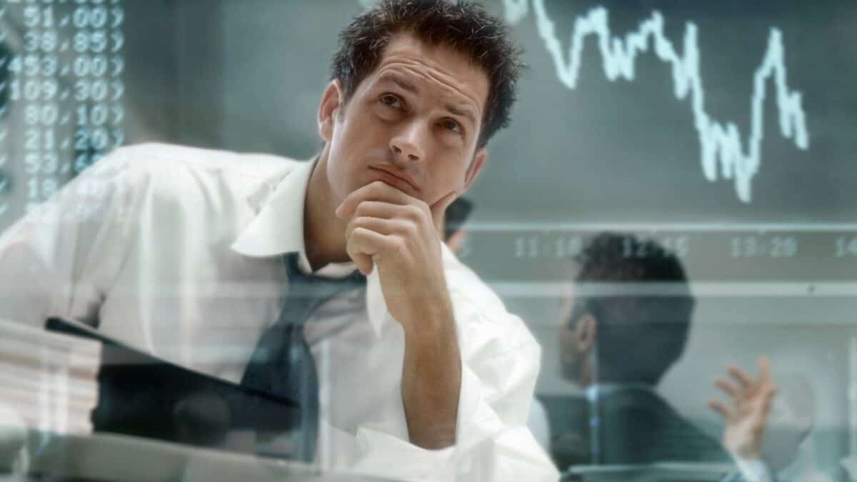 A financial expert or broker looks worried as he checks out a graph showing market volatility.