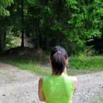 A young woman with a ponytail stands at the crossroads, trying to choose between one way or the other.