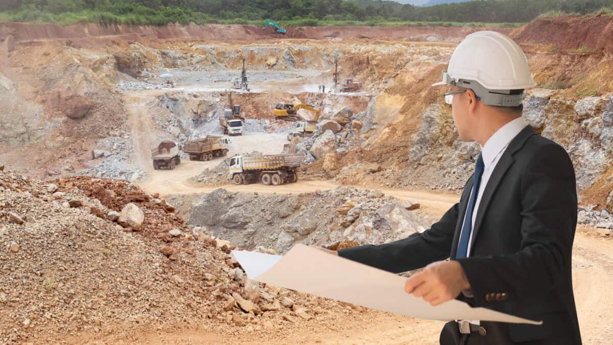 Engineer looking at mining trucks at a mine site.