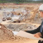 Engineer looking at mining trucks at a mine site.