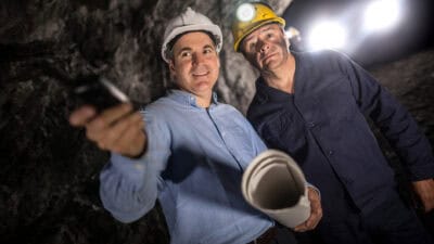 Engineer at an underground mine and talking to a miner.