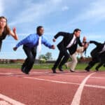 Group of people dressed in business attire racing on track.