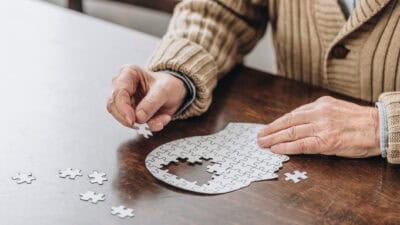 Cropped view of senior man playing with puzzles.