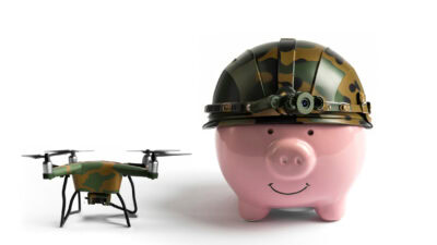 Piggybank with an army helmet and a drone next to it, symbolising a rising DroneShield share price.