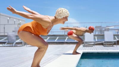 Two people about to dive into a pool.