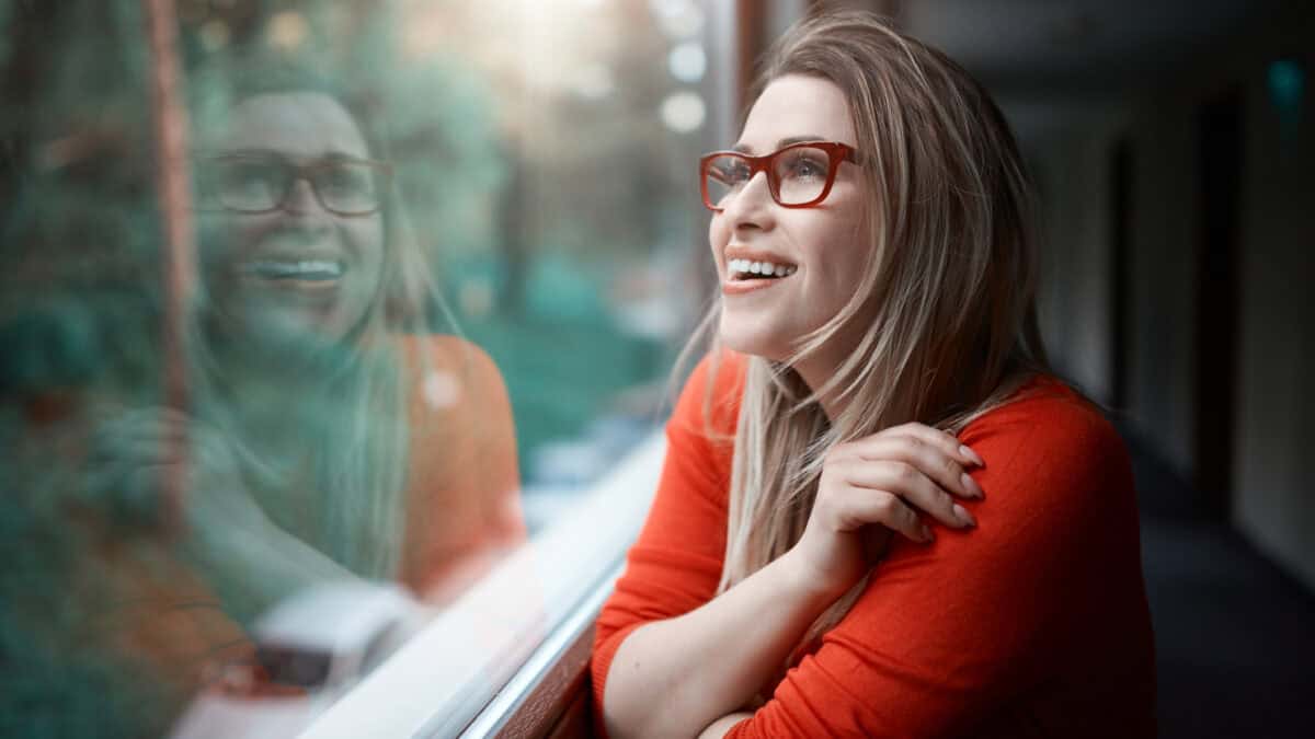 Smiling woman looking through a window.