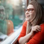 Smiling woman looking through a window.