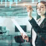 Woman using a pen on a digital stock market chart in an office.